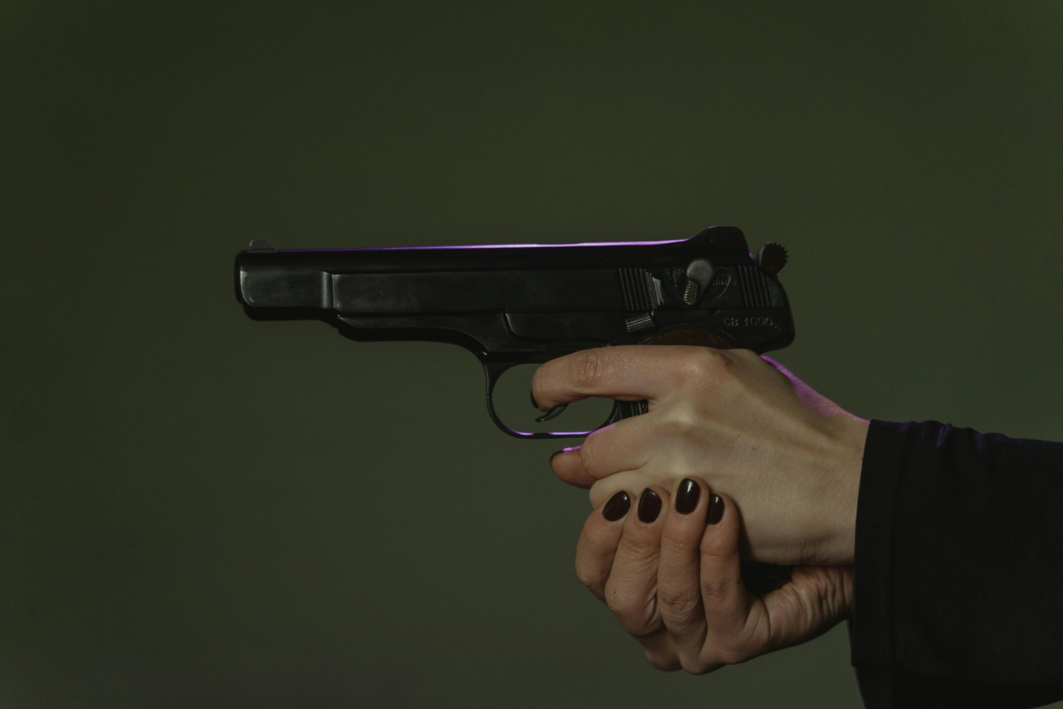 Hands pointing a Beretta pistol